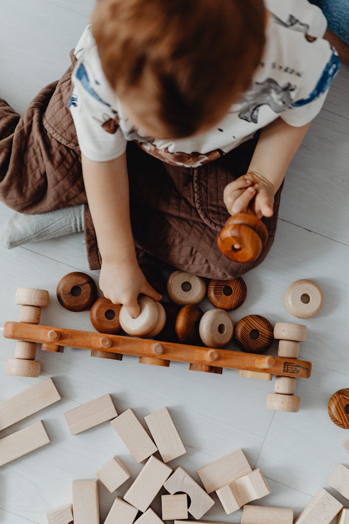 A young child engaged with a wooden puzzle and toy blocks for learning and development.
